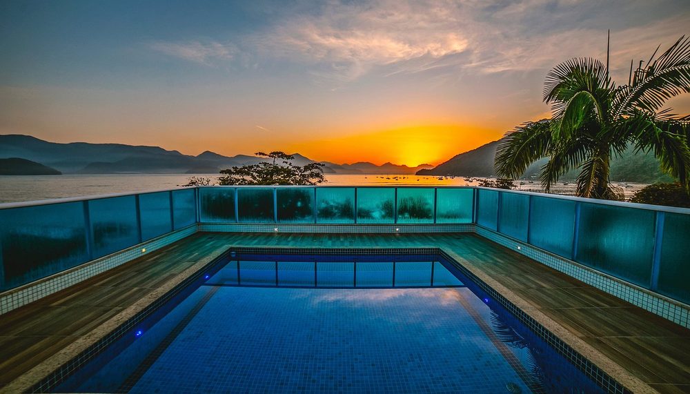Piscina de hotel internacional à beira-mar no pôr do sol